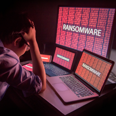 Worried man looking at his laptops attacked by ransomware