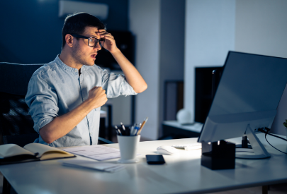 Shocked man looking at his business computer hacked