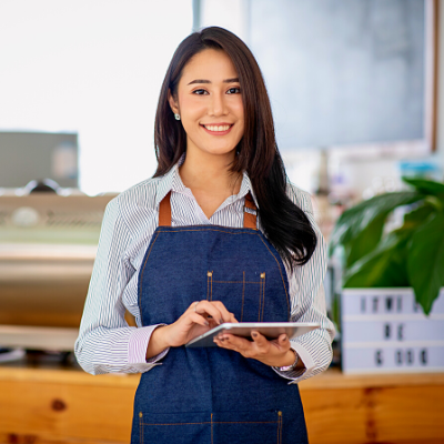 Businesswoman wearing an apron holding a tablet, smiling